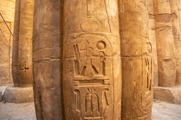 Ancient carvings on stone pillars in Luxor Temple during daylight in Egypt