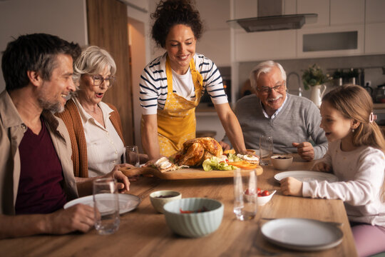 Family gathering serving roasted chicken for lunch