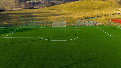 Football training pitch with artificial turf and goal set against natural landscape background