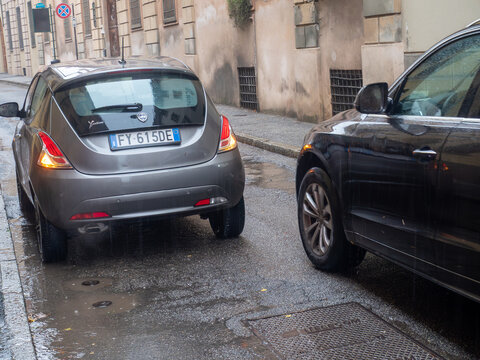 Lancia Ypsilon parked on a wet street during a rainy day in Italy