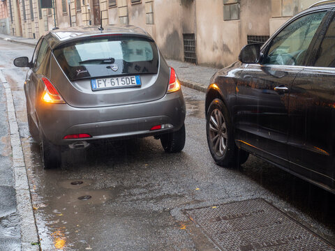 Lancia Ypsilon parked on a wet street during rainfall in an old European city