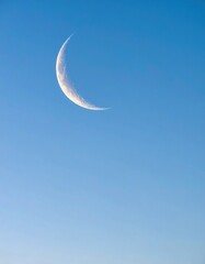 Crescent Moon Shines Brightly in a Clear Blue Sky on a Sunny Day