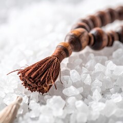 Close Up Of Wooden Prayer Beads With Tassels Resting On Coarse White Crystals With Shallow Depth Of Field