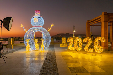 Snowman and 2026 display at sunset in public square with decorations festive atmosphere
