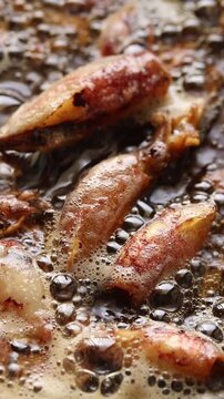 Fried crispy dried cuttlefish (Beka squid) in boiling oil. Top view shot
