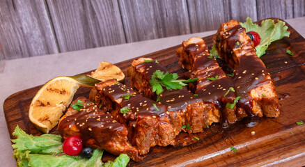 Delicioso platillo navide&ntilde;o de costillas de cerdo a la bbq sobre una tabla de madera