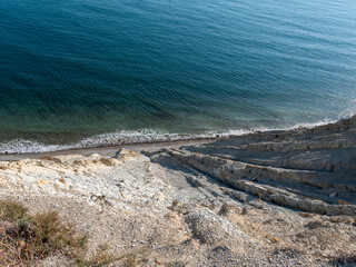 Top view of sea, rocky shoreline and coastal cliffs. Natural seascape with rocks and water, no people