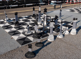 Large outdoor chessboard on asphalt. Giant floor chessboard set up for recreational play