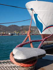 Mooring rope tied to a pier on the shore. Ship rope fastened to the dock in a mushroom shape