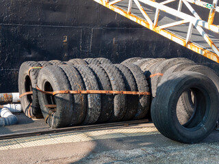 Pile of automobile wheels stacked outdoors. Used car tires and rims in an industrial or storage setting
