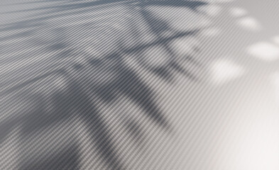 Carbon fiber surface featuring abstract leaf shadows creating a modern background textile