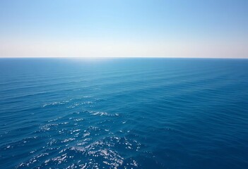 Expansive view of the deep blue ocean, calm surface reflecting sunlight under a clear sky, creating a serene and vast seascape,  sunny,  horizon