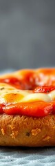Close-up view of a circular bagel base, generously topped with savory marinara sauce and a blanket of molten cheese, ready for enjoyment,  gourmet bite,  appetizer