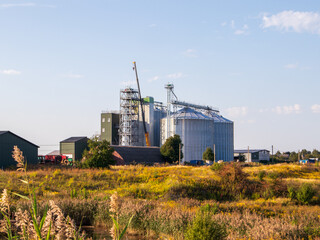 Silos by fields under a clear blue sky