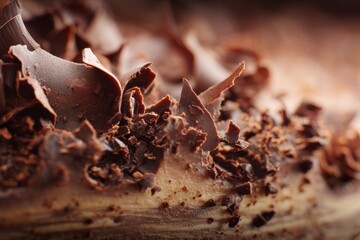 Chocolate shavings are placed on top of a cake, highlighting the texture and layers of the dessert. This shows how the cake is decorated for serving Generative AI