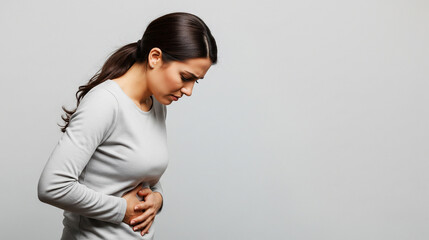 Obraz premium Severe Abdominal Pain: Woman Clutches Her Stomach in Distress