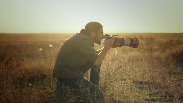 Professional wildlife photographer photographing wild animals in a vast desert landscape during golden hour. Documentary-style nature photography capturing conservation, exploration, adventure, and th