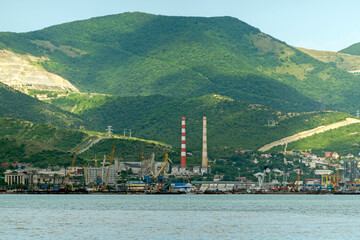 Fototapeta premium August 22 2025 View of Novorossiysk port Russia with cargo ships and cranes on the coastline. Industrial maritime scene on the Black Sea