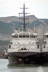 Naklejka premium August 24, 2025: Rescue ships docked in the port of Novorossiysk, Russia, with mountains in the background, illustrating maritime safety, port operations and Black Sea coastal activity