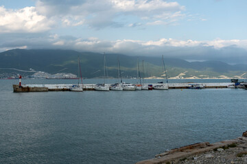Fototapeta premium July 28, 2025: Yacht parking along the waterfront in Novorossiysk, Russia, with moored yachts near the coastline, reflecting maritime life and the Black Sea harbor atmosphere