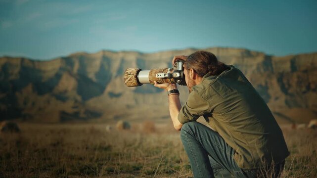 Professional wildlife photographer photographing wild animals in a vast desert landscape during golden hour. Documentary-style nature photography capturing conservation, exploration, adventure, and th