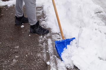 A man is clearing snow from the road