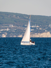 August 22 2025 Sailing yacht Uspekh with white sail on the Black Sea near Novorossiysk Russia. Recreational yacht moving along the coastline.