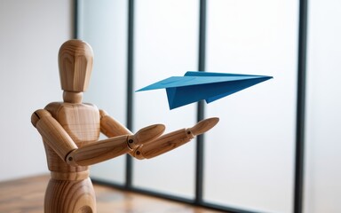 A wooden figurine launching a blue paper airplane in a modern interior space