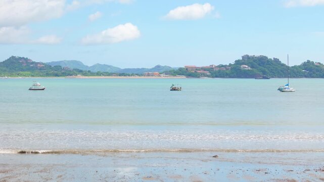 Aerial drone view flying forward and rising over Playa Potrero towards Flamingo Marina