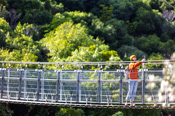 stylish young woman with a backpack takes a selfie in sunny weather. Happy female tourist enjoying her trip. Girl with a backpack.