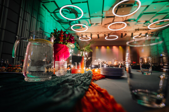 Elegant dining setup featuring a beautifully arranged table with floral centerpiece, glassware, and ambient lighting, creating a festive atmosphere for a special event