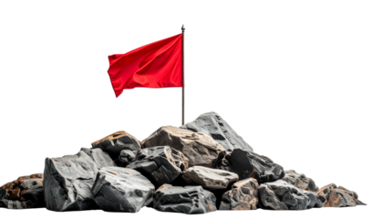 A red flag atop a pile of gray rocks, against a black background