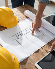 Architect Hands Pointing at Blueprints on Construction Site - Project Planning