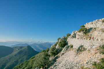 couple walking along the access road to the summit of Mare de Deu del Mon in Girona, Catalonia, Spain