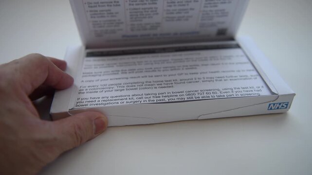 Opening the Bowel Cancer Screening Programme home sample test kit and taking out the contents.