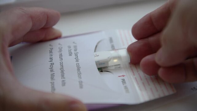 Inserting the test sample in the sample container into the pre paid envelope ready for sending to the Bowel Cancer Screening Programme for testing.