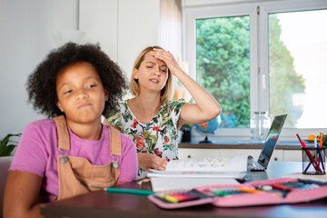 Obraz premium Mother and daughter experiencing frustration during homework at home