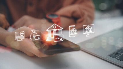 Businessman hand using smartphone with virtual bank icons. Concept of online banking, mobile finance, digital payment, secure money transfer, and financial technology.