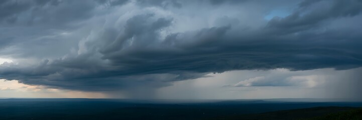 A large storm cloud formation looms over a vast landscape with rolling hills and mountains