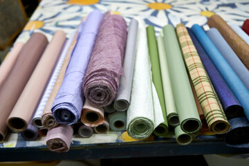 Colorful rolls of wrapping and craft paper neatly arranged on a creative workshop table. Artistic...