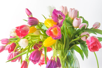 Valentines day or international womens day concept; bunch of colorful tulips in a vase on a white background