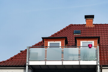 Glazed balcony with a bucket on a rooftop during the day