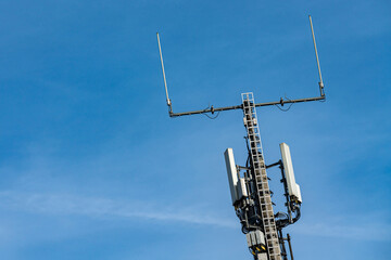 Cell tower stands tall against clear blue sky during the day