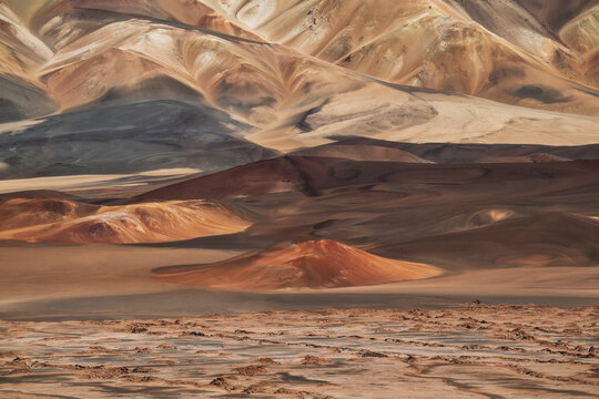 Telephoto shot of multicolored volcanic hills in the High Andes. Excellent texture, natural earth tones, and soft lighting create a painterly, layered mountain landscape.