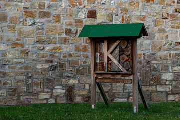 Insect hotel by stone wall in green roof setup