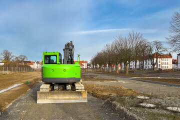 Construction site with green excavator in urban area
