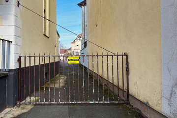 Gate blocks path in narrow alley between buildings in city