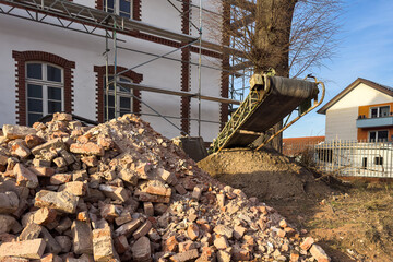 Construction site with bricks and equipment near a building