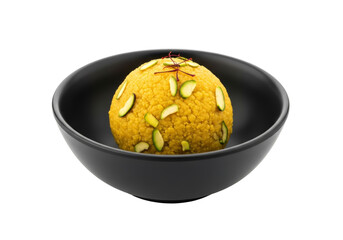 yellow laddu dessert in black bowl with almond slices