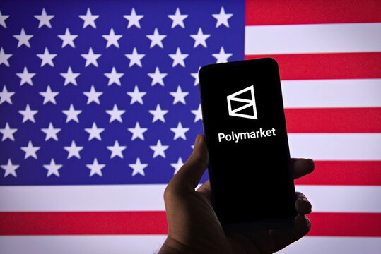 Polymarket logo on a smartphone screen with the US flag in the background.